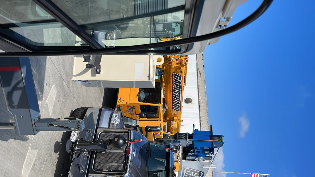 Mobile crane boom serviced against open sky